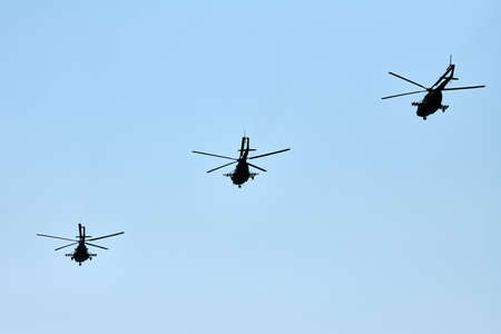 Military helicopters flying in bright blue sky performing demonstration flight, airforce, copy...