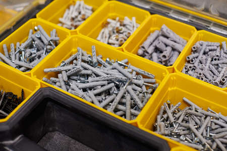 Many storage compartments filled with builders accessories containing screws, nuts, bolts, nails and...