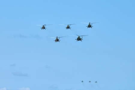Military helicopters flying in bright blue sky performing demonstration flight, airforce, copy...