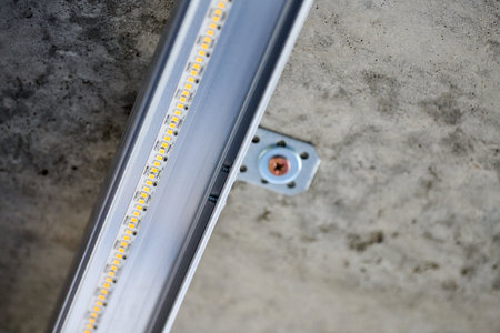 LED strip with aluminum profile on rough wall. Concrete ceiling with LED lighting in residential...