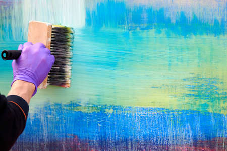 Female painter hand drawing abstract oil painting holding wide brush, abstract art. Acrylic painting on colorful canvas, fragment of artwork. Expressive brushstrokes, modern art, contemporary artの写真素材