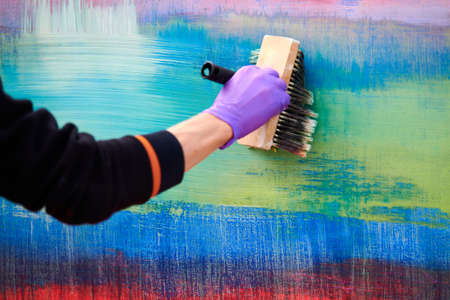 Female painter hand drawing abstract painting holding wide brush. Oil painting on colorful canvas, fragment of artwork with green, red and blue broad brushstrokes, modern art, contemporary artの写真素材