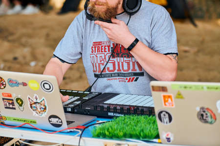 Svetlogorsk, Russia - 08.14.2021 - Disc jockey playing music, remixing on drum machine midi controller. DJ playing beat sampler with drum pads and samples. Deejay makes beats at beach party, close upのeditorial素材