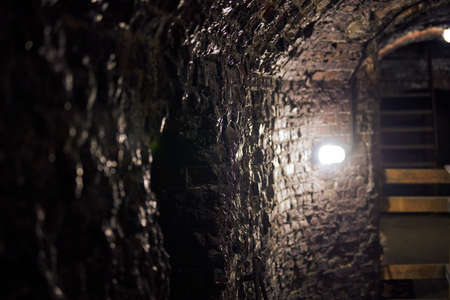 Old brick loft wall in secret military basement. Old wine vault, passageway of mansion. Ancient...