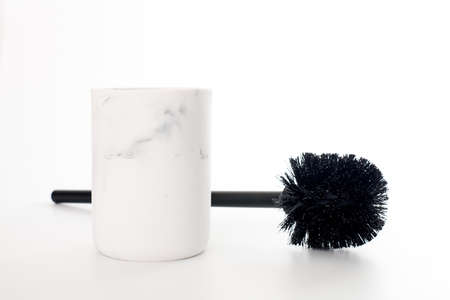 Black toilet brush in modern white stone holder isolated white background. WC tool for cleaning toilet bowl. Brush for toilet cleaner and bleach toilet bowl surfaceの写真素材