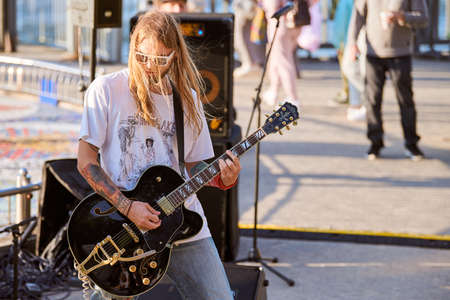 Svetlogorsk, Russia - 08.15.2021 - Rock musician plays guitar at outdoor rock party. Long haired...