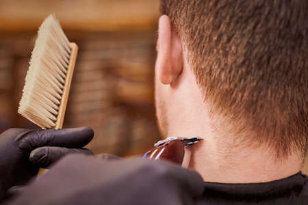 Male haircut trimming in barbershop, client getting haircut by hairdresser with clipper and hairbrush. Hairdresser makes hairdo in hairdresser salon, new stylish modern haircut for manの写真素材