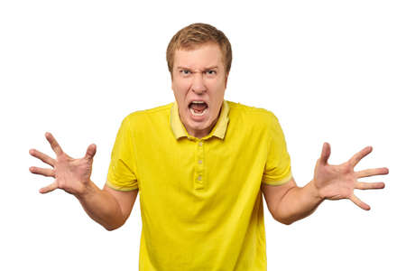 Angry guy in yellow T-shirt spread his hands and yelling isolated on white background. Yelling man in bright yellow T-shirt very angry and annoyed, relationship conflict, quarrel conceptの写真素材