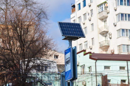 Solar panel on city road sign post, power for bus stop light, environmental friendly ecology electricity. Solar energy panel powered city infrastructure, ecological renewable solar energyの写真素材