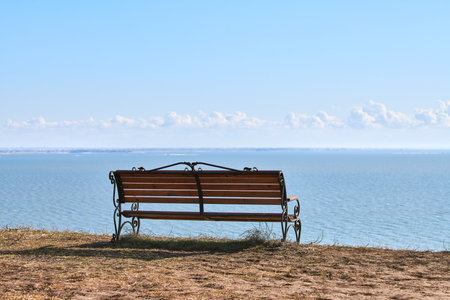 Empty bench on cliff before sea background, peaceful and quiet place for thinking alone, loneliness...