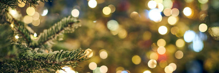 Christmas tree covered snow with yellow garlands lights and bokeh copy space with sparkled lightsの写真素材