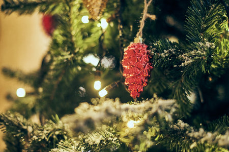 Christmas tree bulbs with yellow garlands covered snow, outdoor xmas tree with decorative red bulbs