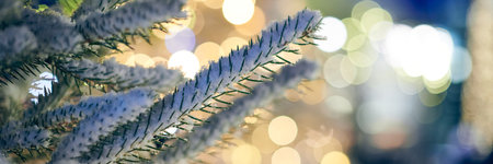 Christmas tree covered snow with yellow garlands lights and bokeh copy space with sparkled bokehの写真素材