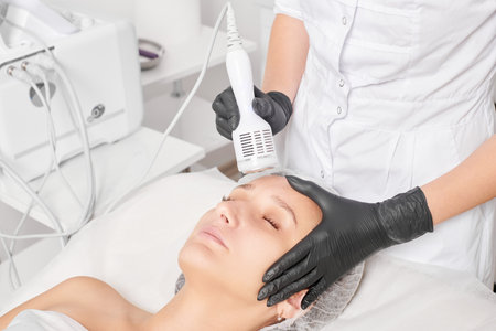 Beautician makes cryotherapy for rejuvenation woman face, anti aging procedure in salonの写真素材