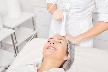 Beautician makes RF lifting for rejuvenation woman face, anti aging cosmetic procedureの写真素材