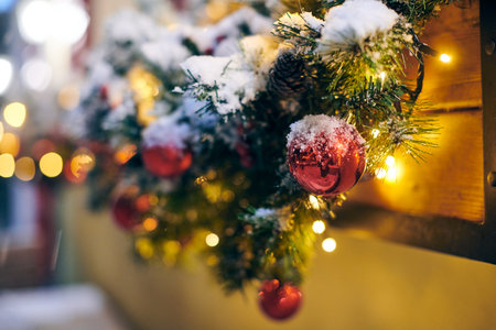 Christmas tree decorations with yellow garlands covered snow, outdoor xmas tree with red bulbsの写真素材