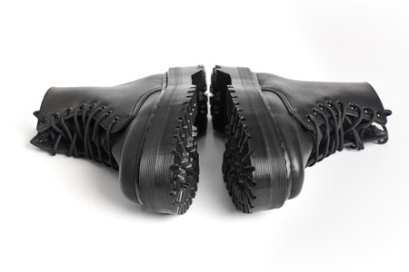 Black women combat boots on high heel platform with lug soles lying on isolated white background....