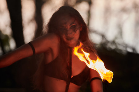 Girl fire dancing performance at outdoor art festival, smooth movements of female artist
