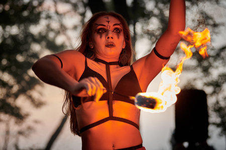 Girl fire dancing performance at outdoor art festival, smooth movements of female artist