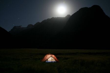 Moon rising over a tent in the wildernessの写真素材