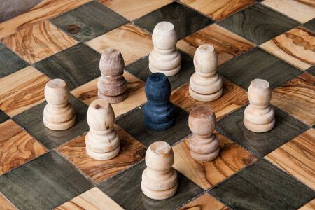 black pawn ringed by some white pawnsの写真素材