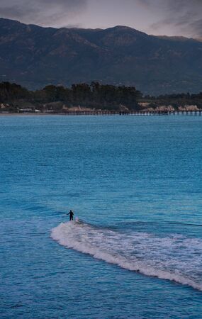 longboard surfer in santa cruz, california from the distance