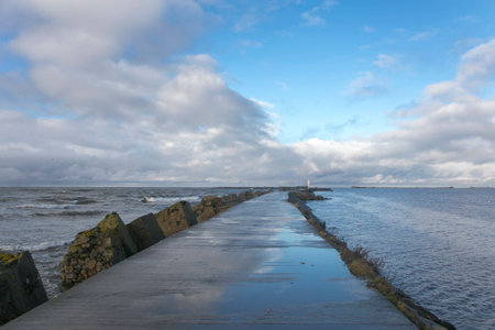 The lighthouse and the breakwater on Baltic sea, Liepaja, Latviaの写真素材
