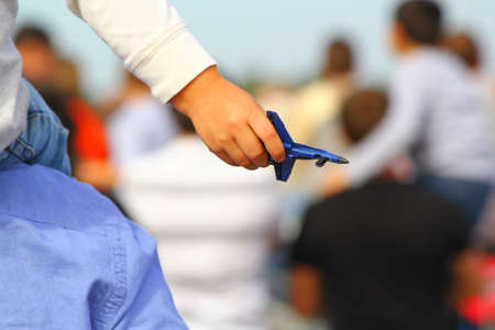 A child gripping a toy jet plane in his hand at an air showの写真素材