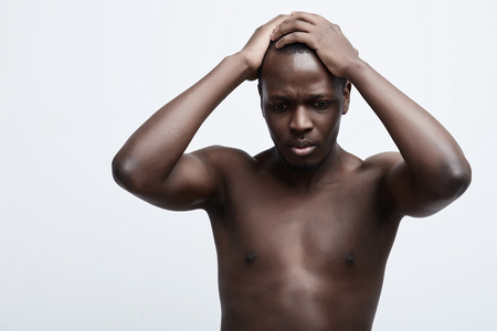 Negative emotion concept stressed man. Closeup headshot very sad depressed, disappointed gloomy young man head on hands screaming in despair isolated on grey wall background. Human emotion facial expression reactionの写真素材