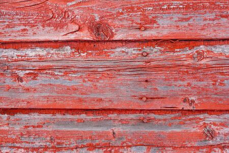A background image of peeling red paint on old barn boards の写真素材