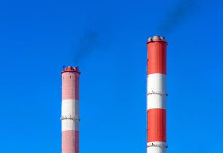 Pipe CHP chimneys against the blue sky with cloudsの写真素材