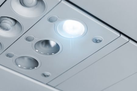 Modern passenger airplane cabin details passenger service unit panel light closed air conditioner attendant call buttonsの写真素材