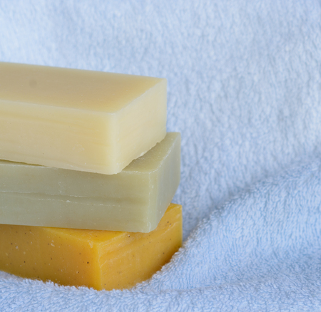 Stack of handmade soap bars on blue bath towelの写真素材