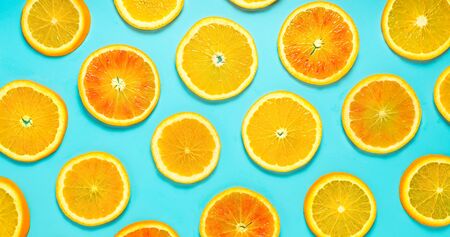 Fruit pattern of orange slices on turquoise background. Top view.