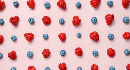 Colorful fruit pattern of raspberries and blueberries on pink background. Flat layの写真素材