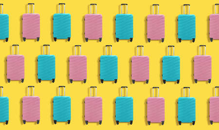 Colorful travel plastic suitcases pattern on yellow background.の写真素材