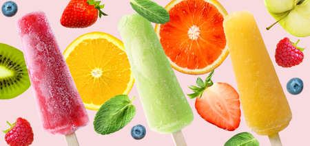 Bright sticks with juicy fruits and berries on a pink background. Hot Summer background