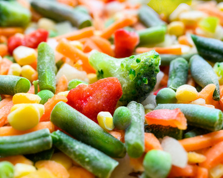 Frozen vegetable mix closeup. Chopped mixture of carrots, corn, peas, legume, broccoli and pepper. Shallow DOFの写真素材