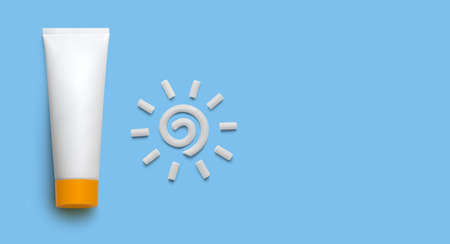 White blank cosmetic tube with sunscreen cream and plasticine sun on blue background. Mockup