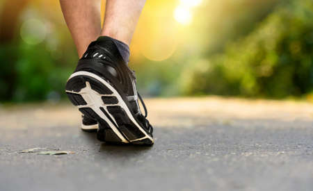 Legs of a jogger in shoes close-up in the park