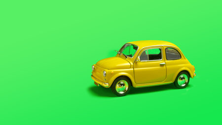 Miniature yellow toy car on green background with copyspaceの写真素材