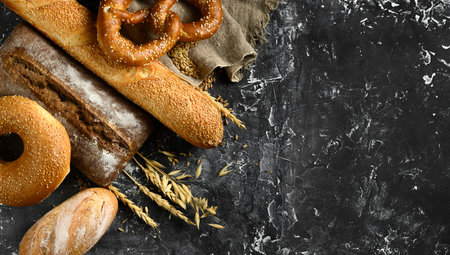 Fresh baked bread assortment on black board background. Top viewの写真素材