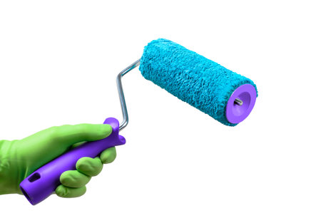 Blue painting roller brush in hand isolated on whiteの写真素材