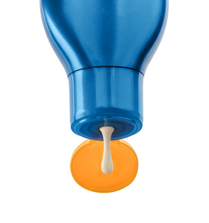 Blue Plastic bottle of sun protection lotion and flow white cream on white background.の写真素材