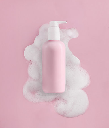 Elegant Pink Pump Bottle Beautifully Surrounded by Soft Cosmetic Foamの写真素材