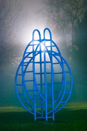 Back-lit children's playground equipment on a foggy night.の写真素材