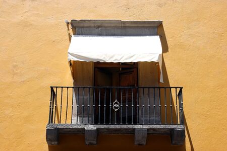 Colonial balcony. View on a typical urban scene with closed French window, Mexicoの写真素材