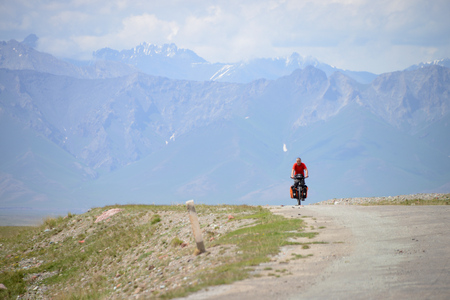 Long distance cycling on the M41 Pamir Highway near the Kyrgyz / Tajik border, Pamir Mountain Rangeの写真素材
