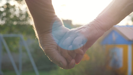 Elderly Old Couple Holding Hands On Background Of Green Nature At Sunset Shineの写真素材