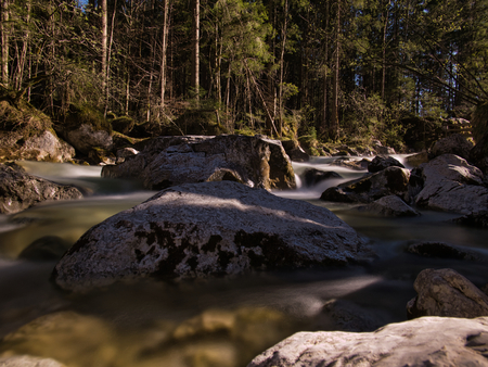 A mountain stream at a clearing with large rocks in the waterの写真素材